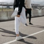 Dorośli w sporcie rozciągający się na miejskiej ulicy