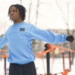 Mężczyzna w sportowym stroju rozciąga się zimą w ośnieżonym parku